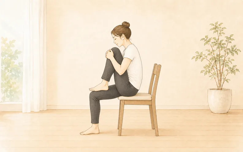 椅子ヨガ 片膝を抱えるポーズをとる女性