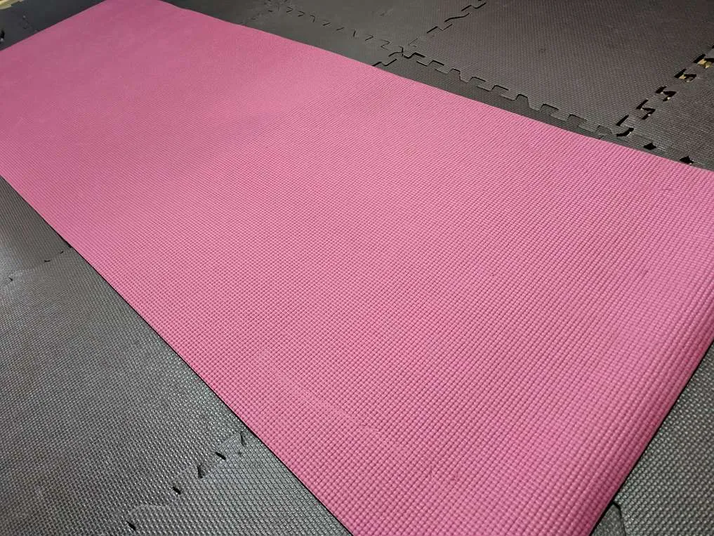 ダイソーの660円のヨガマットを広げている